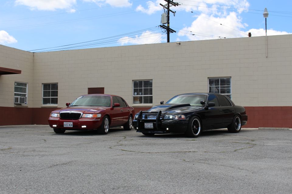 Maroon Mercury and black Ford with grille guard angled in a lot