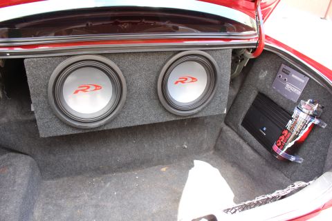 2003 Ford Crown Victoria - Car trunk fitted with a dual-subwoofer enclosure and a mounted amplifier with coiled power wiring.