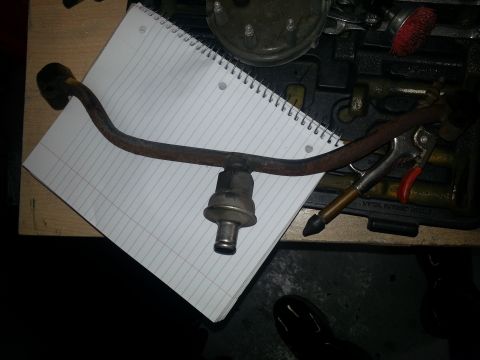 1994 Ford Bronco - Fuel pressure regulator and line on a notepad with tools in the background.