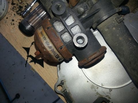 1994 Ford Bronco - A rusty fuel pressure regulator, likely from a Ford vehicle, is shown with its part number clearly visible.
