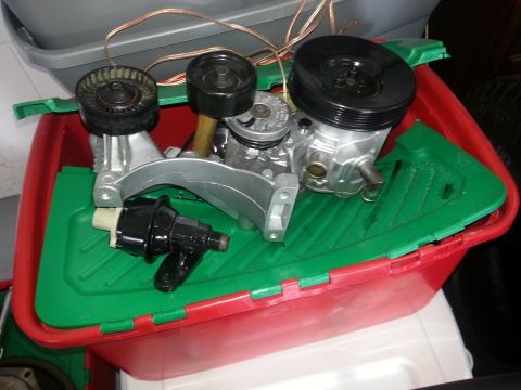 1994 Ford Bronco - Various engine components are laid out in a storage container, suggesting a repair or project.