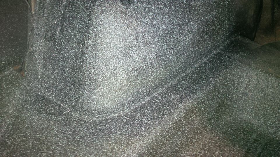 Underside of a vehicle, possibly a trunk area, with textured coating. Supermotors logo visible