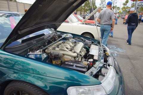 1995 Ford Taurus - A green car's engine bay is displayed with the hood open, revealing the V6 engine and other components.