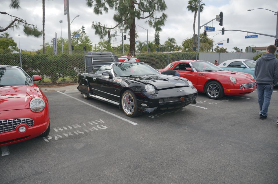 Black convertible Ford Thunderbird parked in a lot with other Thunderbirds