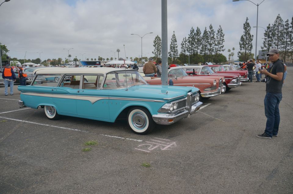Blue and white 1959 station wagon parked in a lot with other classic cars