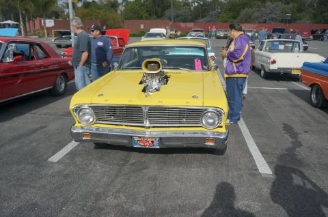 1995 Ford Taurus - A modified yellow Ford Falcon is parked at a car show, drawing attention with its prominent engine scoop.