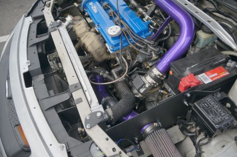 1995 Ford Taurus - Customized engine bay bright purple intake piping and blue valve covers.