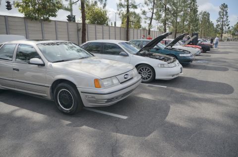 1995 Ford Taurus - A silver 1995 Ford Taurus is parked in a line with other vehicles at an outdoor car show.