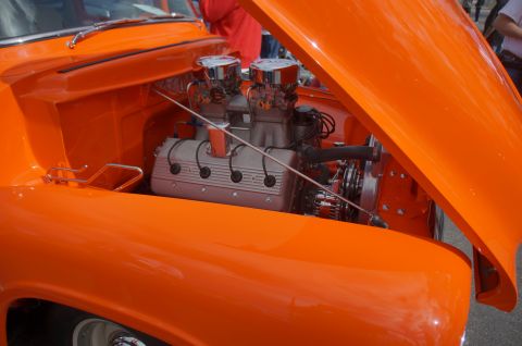 1995 Ford Taurus - The engine bay of a custom orange truck is on display with its hood open.