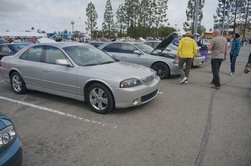Silver sedan parked in a lot, front quarter view. Chrome wheels and grille are visible