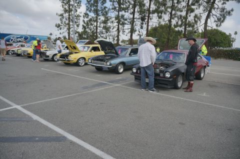 1995 Ford Taurus - Cars gathered at an outdoor event, with attendees examining the vehicles.