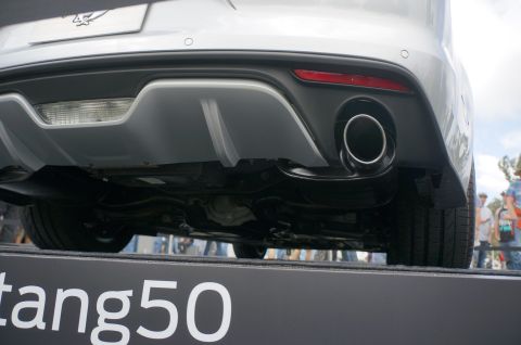 1995 Ford Taurus - The rear of a silver Ford Mustang is shown, with its exhaust pipes and diffuser clearly visible.