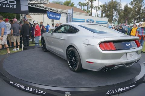 1995 Ford Taurus - A silver 2015 Ford Mustang GT is displayed on a rotating platform at an outdoor event.