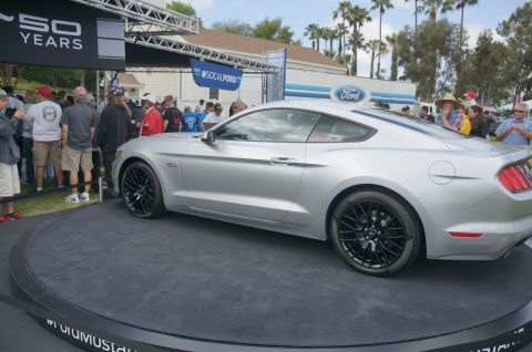 1995 Ford Taurus - Silver Ford Mustang coupe on display at an event with a "50 YEARS" banner and Ford branding.
