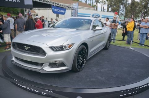 1995 Ford Taurus - A silver Ford Mustang is displayed on a rotating platform at an outdoor car show.