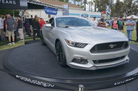1995 Ford Taurus - Silver Ford Mustang displayed at an event, with #FordMustang hashtag on the platform.