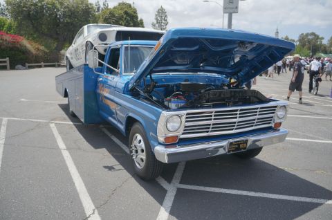 1995 Ford Taurus - A blue 1969 Ford F-Series tow truck is parked with its hood open, carrying a white car on its bed.