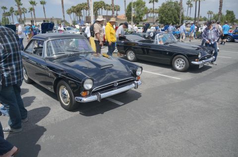 1995 Ford Taurus - Two black sports cars, a coupe and a convertible, are parked side-by-side at an outdoor car show.