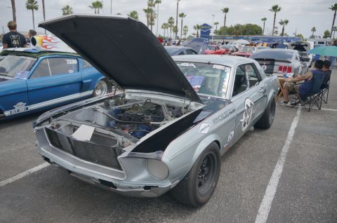 1995 Ford Taurus - A silver 1967 Ford Mustang race car is displayed with its hood open, revealing the engine compartment.