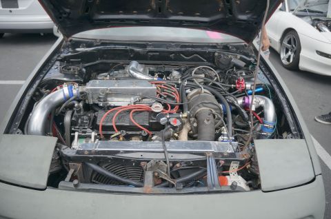 1995 Ford Taurus - Customized engine bay a turbocharger and intercooler. Another white car is visible in the background.