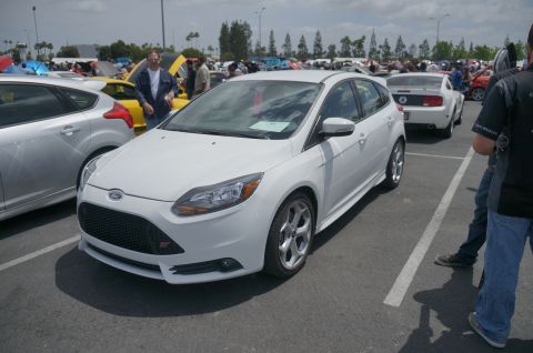 1995 Ford Taurus - White Ford Focus ST with an 'ST' badge on the grille is parked at a car show.