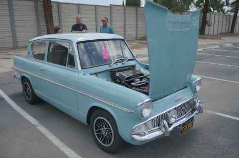 1995 Ford Taurus - A light blue classic car is parked in a lot with its hood open, revealing the engine compartment.