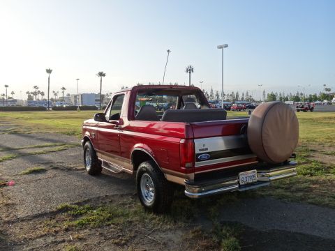 1994 Ford Bronco - Rear view of a red Ford Bronco parked outdoors on a sunny day.