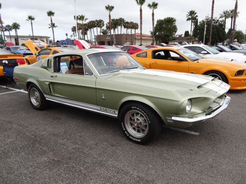 1994 Ford Bronco - A light green 1967 Shelby GT500 Mustang is parked at an outdoor car show with other vehicles.