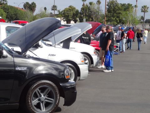 1994 Ford Bronco - Several trucks are lined up with hoods open at an outdoor event.
