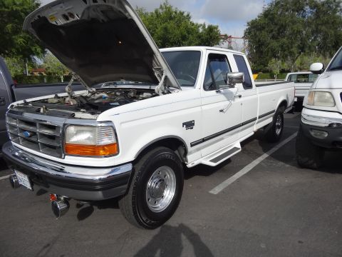 1994 Ford Bronco - This white Ford F-250 pickup truck has its hood open, revealing the engine compartment.
