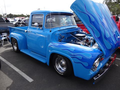 1994 Ford Bronco - This custom blue 1956 Ford F-100 pickup features flame decals and its hood is open, revealing the engine.
