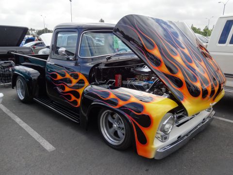 1994 Ford Bronco - Customized 1956 Ford F-100 pickup truck with flame graphics and an open hood.