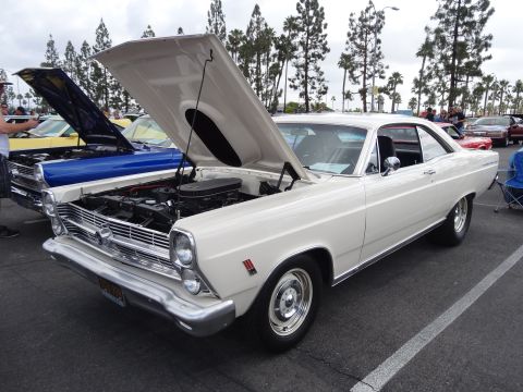 1994 Ford Bronco - A white 1966 Ford Fairlane GT is displayed with its hood open at an outdoor car show.