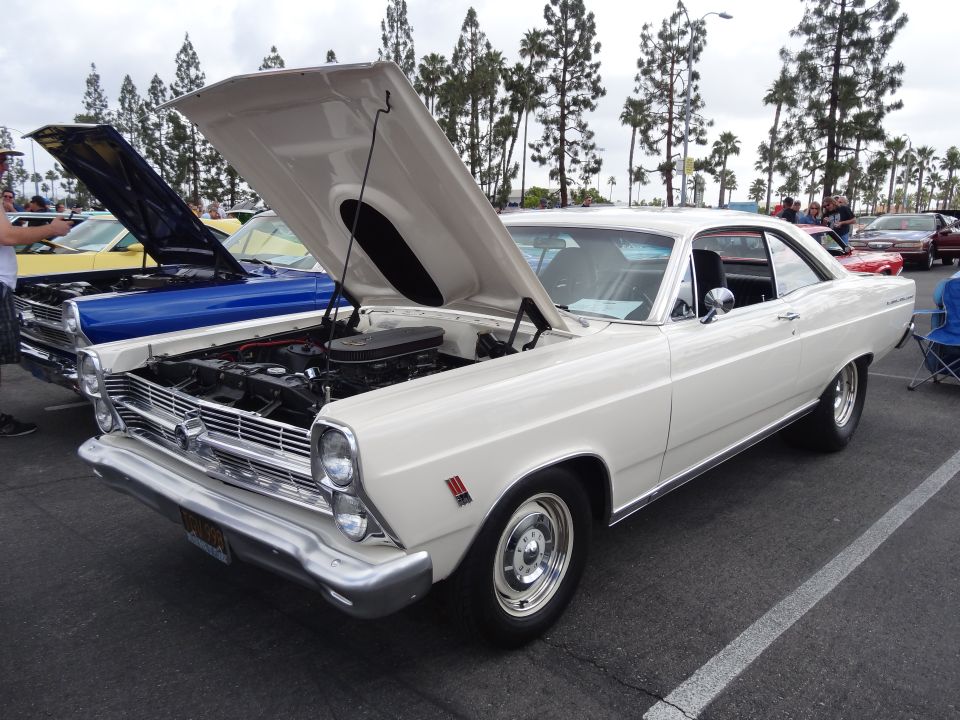White 1966 Ford Fairlane GT with hood open, parked next to a blue car
