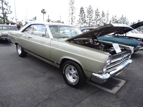 1994 Ford Bronco - A classic 1966 Ford Fairlane GT is displayed with its hood open at an outdoor car show.