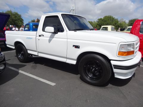 1994 Ford Bronco - White 1992 Ford F-150 pickup truck with black wheels parked outdoors.