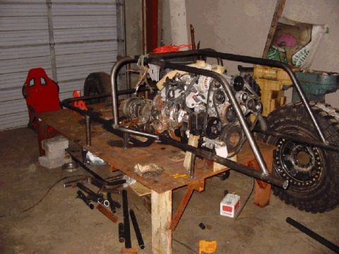 1994 Ford Bronco - A custom off-road buggy frame is under construction, an engine and a red racing seat.