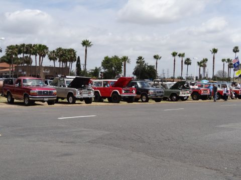 1994 Ford Bronco - A collection of vintage Ford trucks and SUVs are lined up outdoors under a cloudy sky.