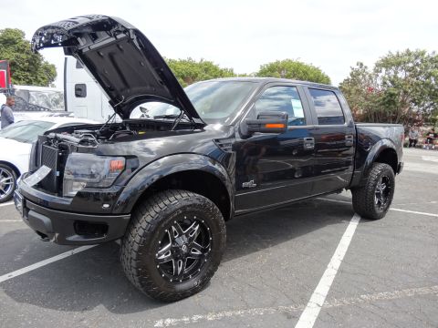 1994 Ford Bronco - Black Ford F-150 Raptor pickup truck with hood open, parked outdoors.