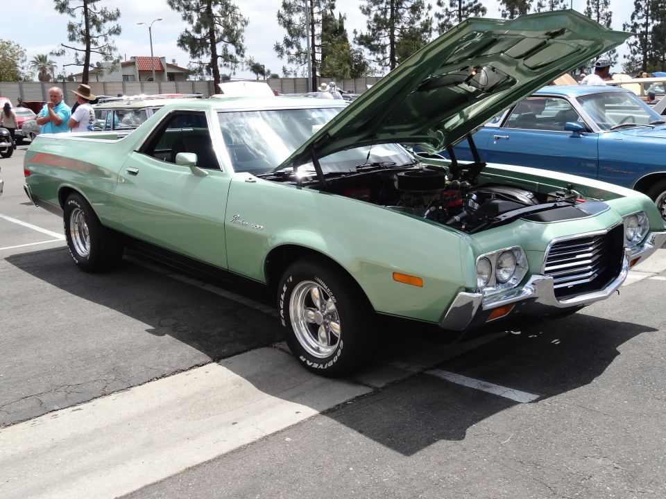Light green 1972 Ford Ranchero pickup with hood open, showing engine. Chrome grille, aftermarket wheels