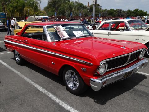 1994 Ford Bronco - This red 1963 Ford Falcon Sprint coupe is parked at an outdoor car show next to a white sedan.