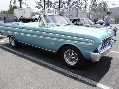 1994 Ford Bronco - A light blue 1963 Ford Falcon convertible is parked next to another vehicle.