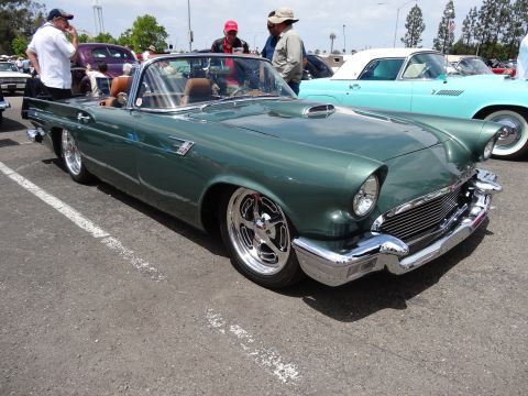1994 Ford Bronco - A green 1957 Ford Thunderbird convertible is parked next to a light blue convertible.