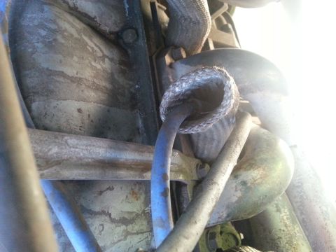 1992 Ford Bronco - Close-up view of engine components, including hoses and metal parts, with visible wear and tear.