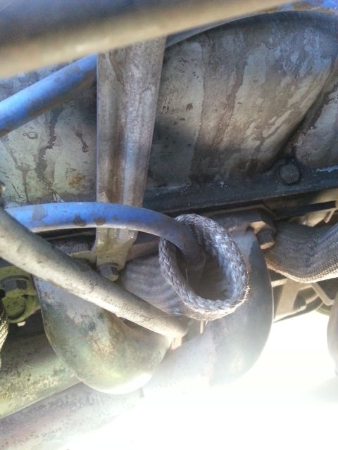 1992 Ford Bronco - Engine bay components including braided hose and metal pipes are visible in this close-up shot.