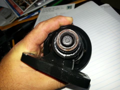1994 Ford Bronco - A hand holds a black oil filter housing, showing internal seals and mounting points.