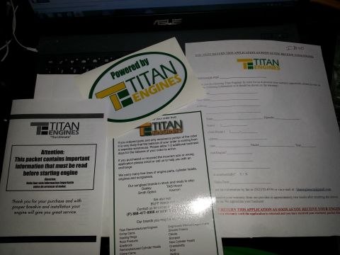 1994 Ford Bronco - Photograph of Titan Engines literature including a warranty application, sticker, and info sheets spread on a desk.