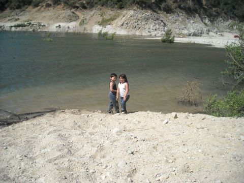 1988 Ford Bronco - Two children stand on the edge of a lake, with a rocky hillside visible across the water.