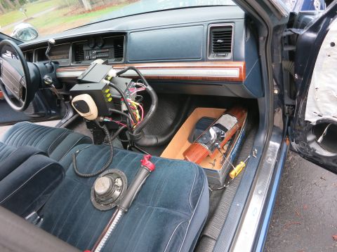 1991 Ford LTD Crown Victoria - The interior of a police car shows various electronic equipment and wiring installed on the dashboard and passenger side.