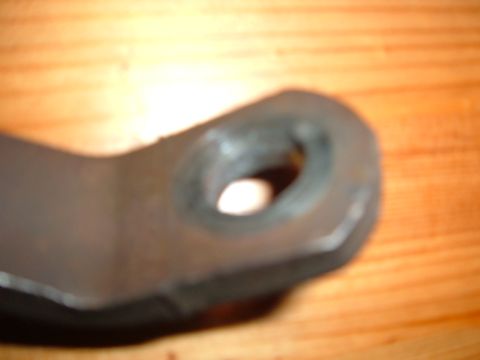 1988 Ford Bronco - A metal bracket is shown in close-up against a wooden background.